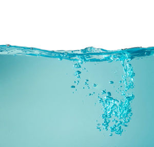 Close-up of water splashing against blue background