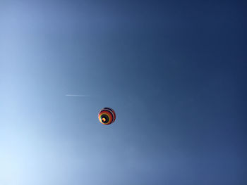 Low angle view of hot air balloon against clear blue sky