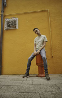 Full length of young man leaning against wall