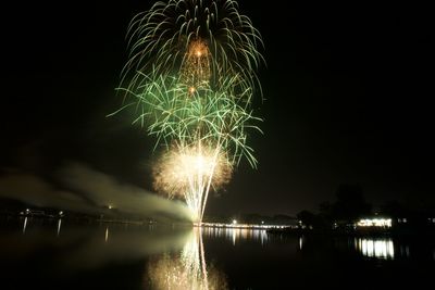 Firework display over river at night