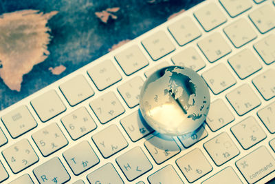 High angle view of crystal ball on computer keyboard
