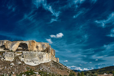Low angle view of mountain against cloudy sky