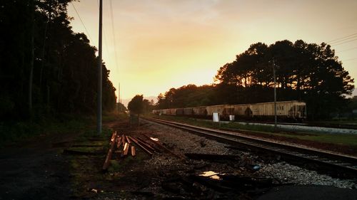 Railroad tracks against sky during sunset