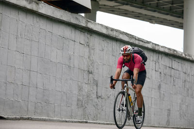 Rear view of man riding bicycle on street