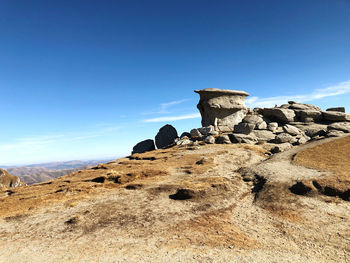 Rock formations on landscape against blue sky