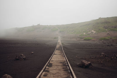 Railroad track on mountain against sky