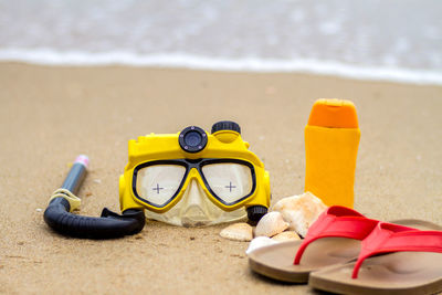 Close-up of shoes on beach