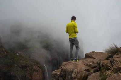 Rear view of man standing on rock