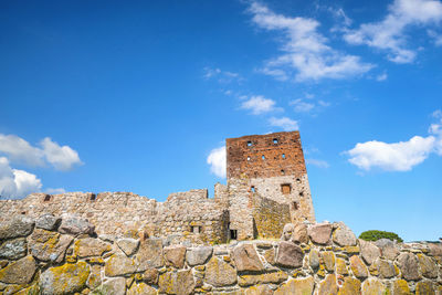 Low angle view of old building against blue sky