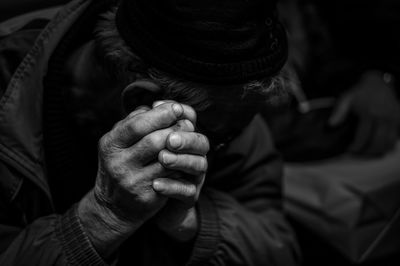 Close-up of senior man with hands clasped