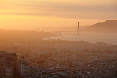 View of suspension bridge in city during sunset