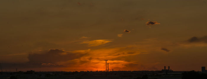 Silhouette cityscape against sky during sunset