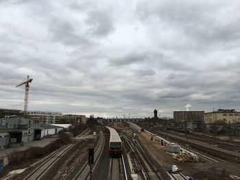 Railroad tracks against cloudy sky