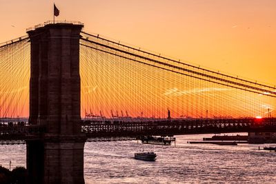 Bridge over river against sky during sunset