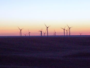 Wind turbines in sea during sunset