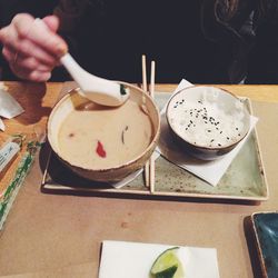 Close-up of hand holding ice cream served on table
