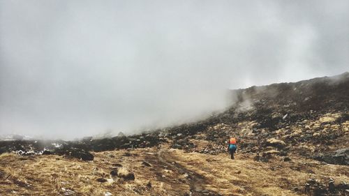 Scenic view of man on mountain against sky