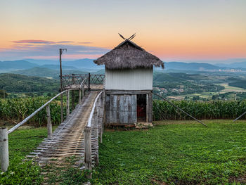 Built structure on field against sky during sunset