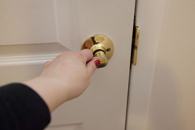 Close-up of hand holding glass door at home