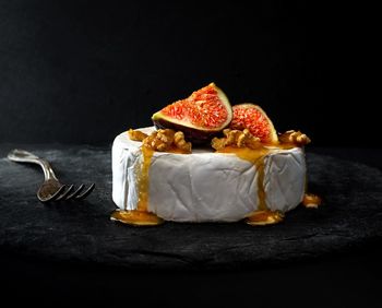 Close-up of orange fruits on table against black background