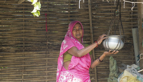 Portrait of mature woman wearing sari holding container