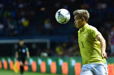 Man playing soccer ball against blurred background