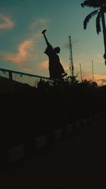 Silhouette man jumping at sunset
