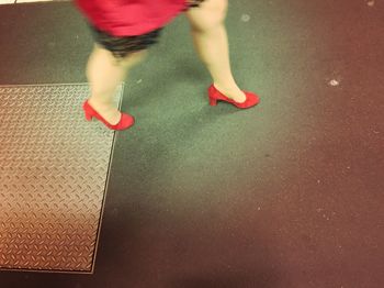 Low section of woman standing by railing