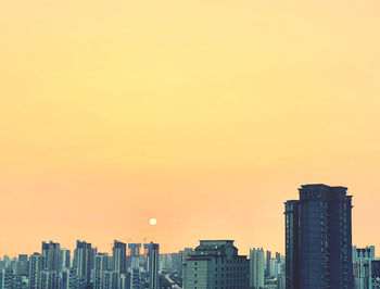 Modern buildings against clear sky during sunset