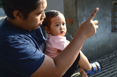 Father and son looking at mother