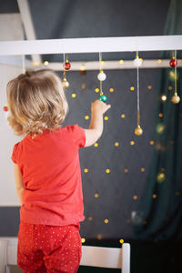 Kid girl red pajamas decorating room christmas. winter holidays, new year eve