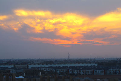 Aerial view of cityscape against dramatic sky
