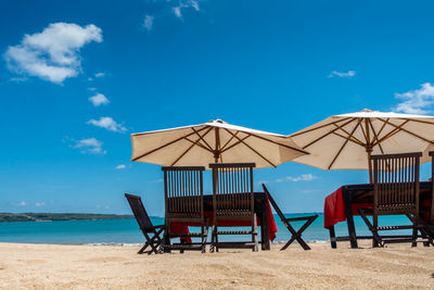 Lifeguard hut on beach against blue sky