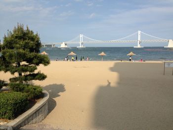 Suspension bridge over sea against sky