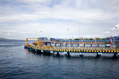 Pier over sea against cloudy sky