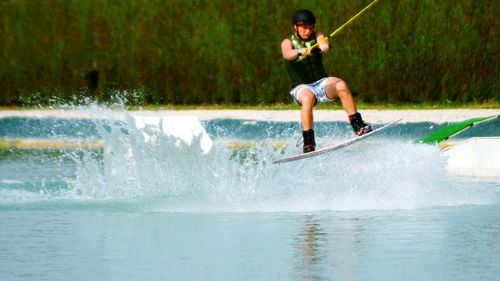 Young man kiteboarding on sea