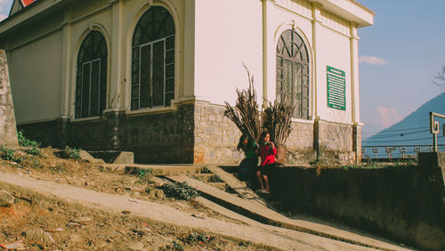 Rear view of woman standing by building in city