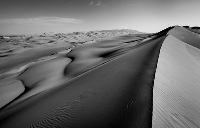 Scenic view of sand dunes against sky