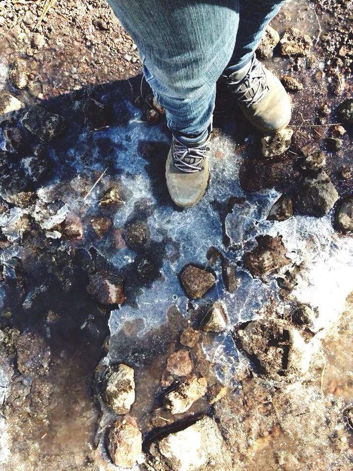 low section, person, water, standing, high angle view, shoe, lifestyles, rock - object, leisure activity, human foot, stone - object, puddle, men, outdoors, nature, day, unrecognizable person