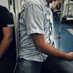 Low section of men sitting in bus