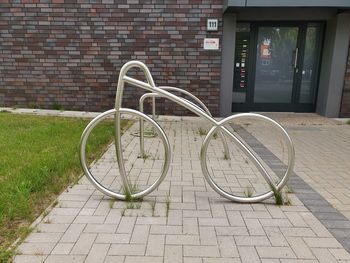 Bicycle on footpath against brick wall