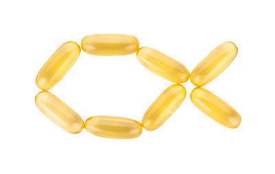 Directly above shot of yellow pills on white background