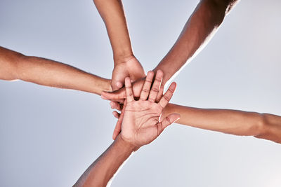 Cropped hands of couple holding hand against white background