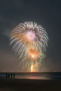 Firework display over sea at night
