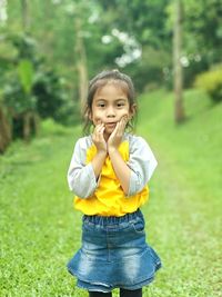 Portrait of cute girl standing on field