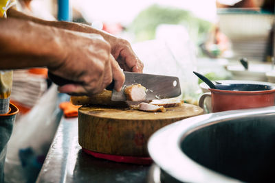 Cropped hand of man chopping food