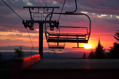 Low angle view of overhead cable car against sky at sunset