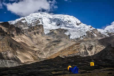 People on snowcapped mountain against sky