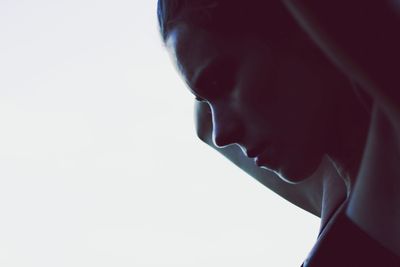 Side view of young woman against white background