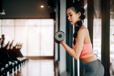 Side view of young woman standing at home